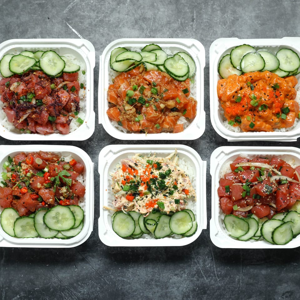 Six takeout bowls of colorful poke-style dishes with rice, sliced cucumbers, seafood, sauces, herbs, and garnishes arranged on a dark surface.